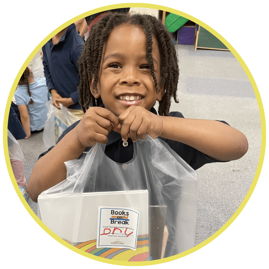 A photo of a Black boy smiling at the camera and holding up a clear bag with books in it in a circular yellow frame. 